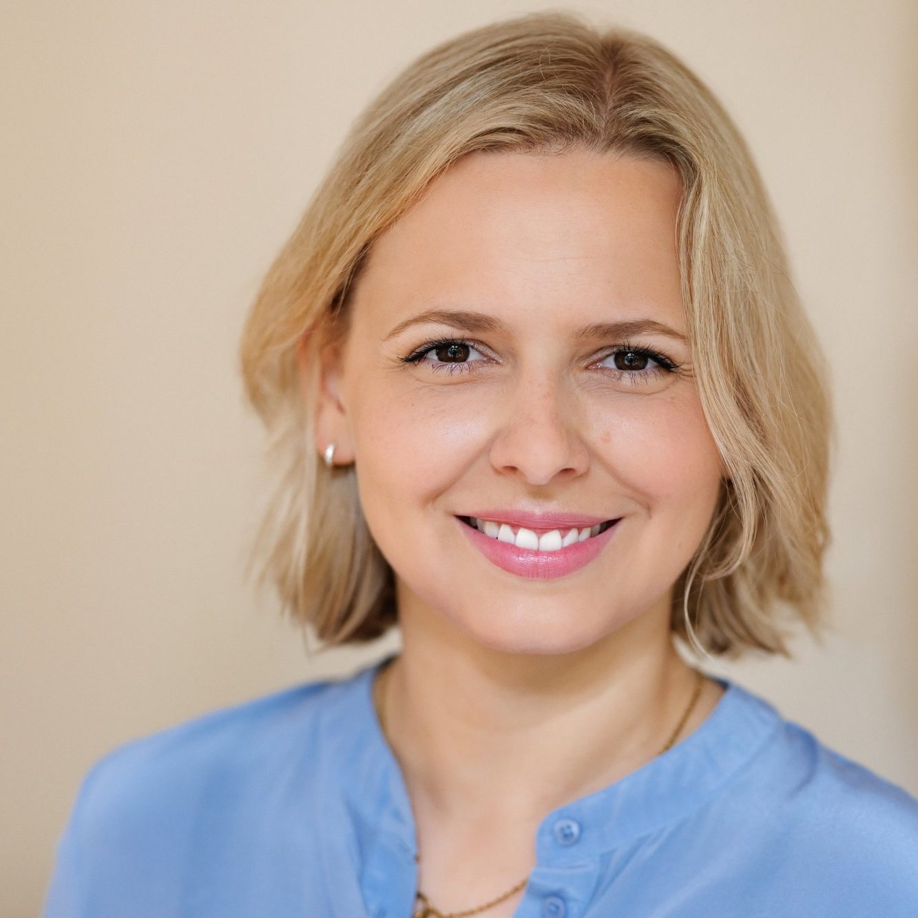 Foto Dr. med. Natalie Börsch Frau mit blonden Haaren lächelt freundlich, trägt ein blaues Oberteil.