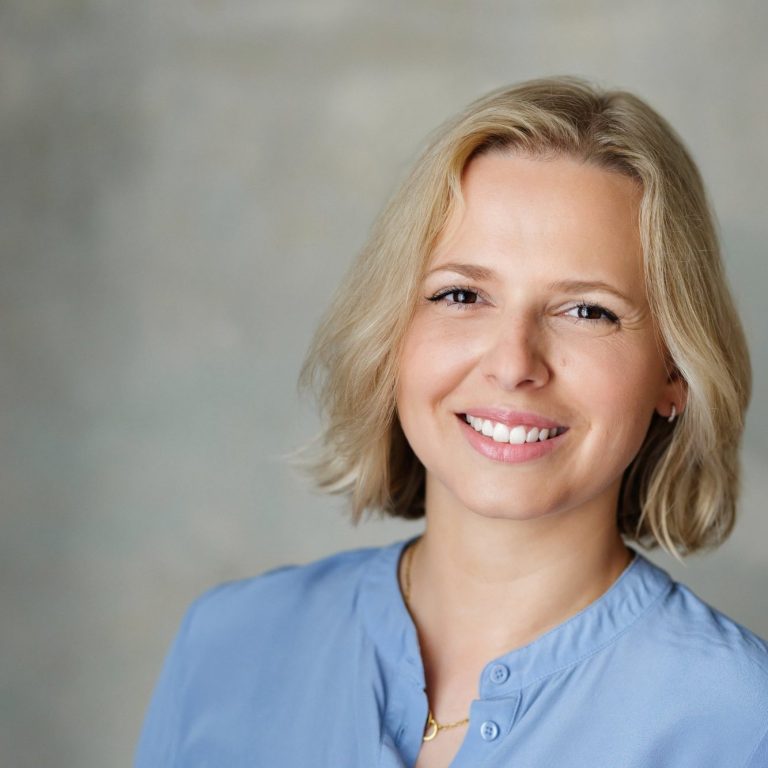 Foto Dr. med. Natalie Börsch Frau mit blonden Haaren lächelt, trägt ein hellblaues Oberteil vor neutralem Hintergrund.