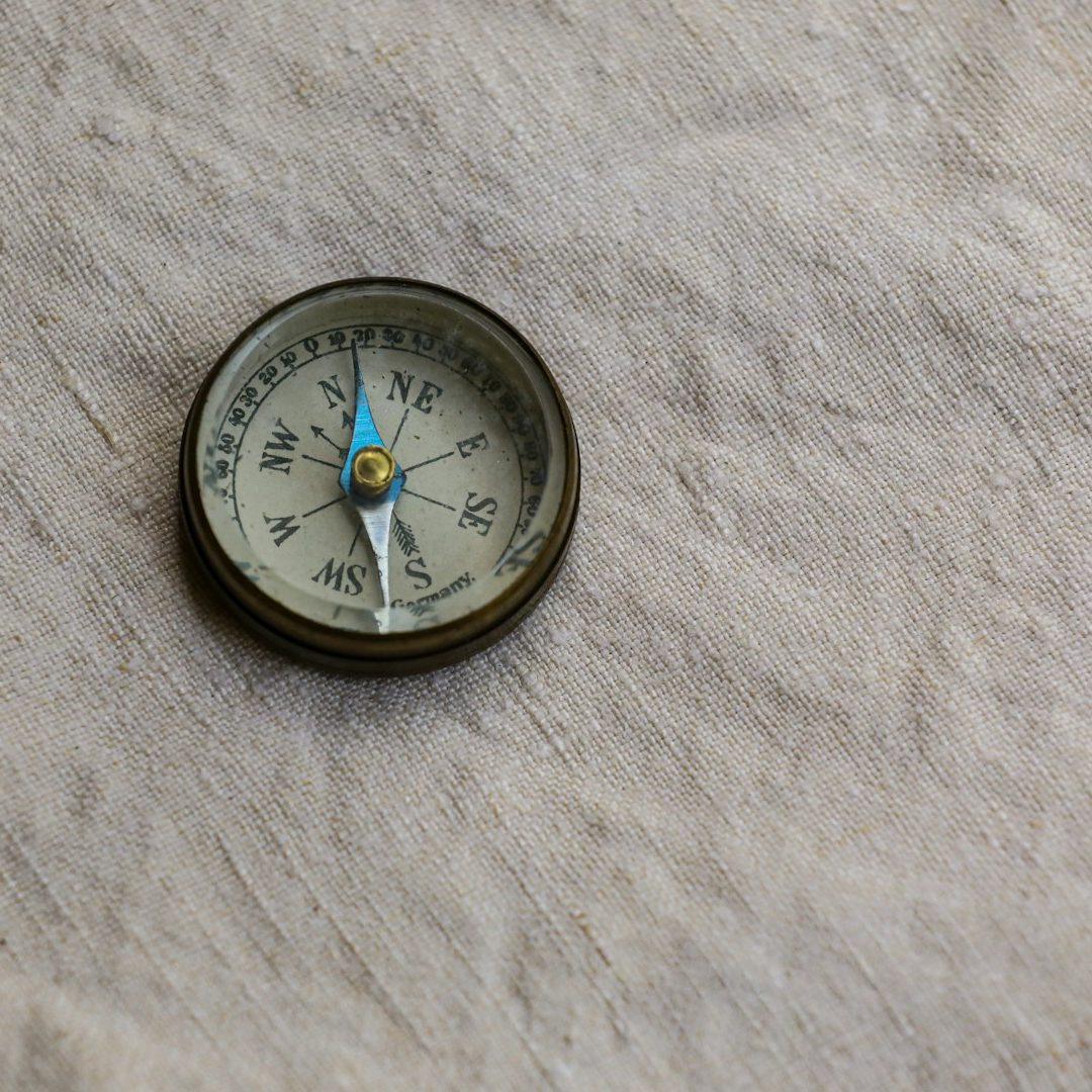 Kompass Ein Kompass auf einer hellen, strukturierten Oberfläche.